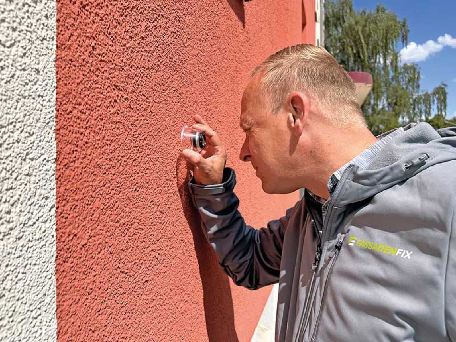 FassadenFix®-Mitarbeiter bei der jährlichen Fassadeninspektion an einer gereinigten Fassade