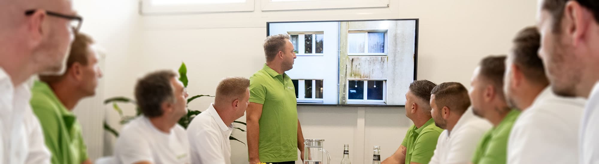 Das FassadenFix-Team bei einer Schulung vor einer Vorher-Nachher-Aufnahme