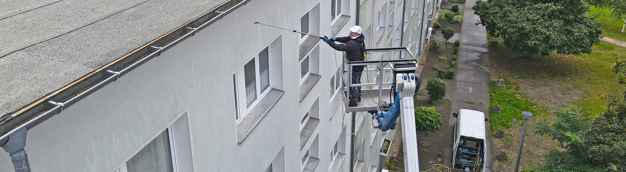 Ein FassadenFix Mitarbeiter bei der Fassadenreinigung